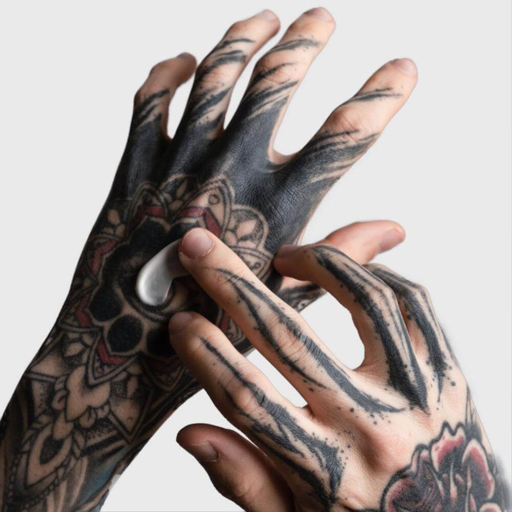 Getatoeëerde hand met TattooMed After Tattoo crème aangebracht – verzorging en hydratatie voor nieuwe tattoos