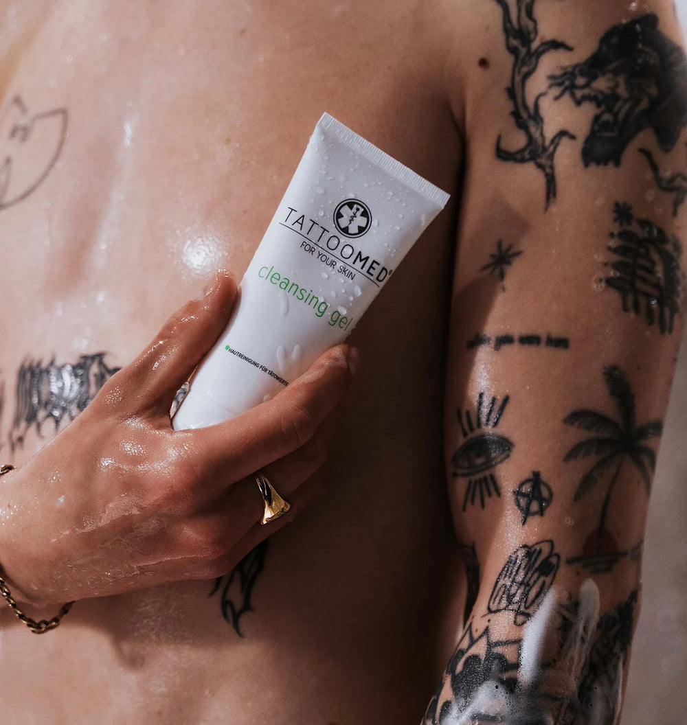Getatoeëerde persoon gebruikt TattooMed Cleansing Gel onder de douche – milde reiniging voor nieuwe tattoos